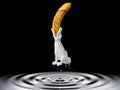 White 3D printed crocodile banana holder holding a ripe banana in its jaws