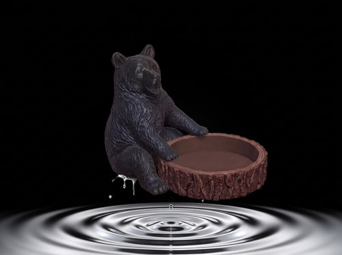 3D printed bear figure sitting with its arms raised, holding a glass honey jar above its head